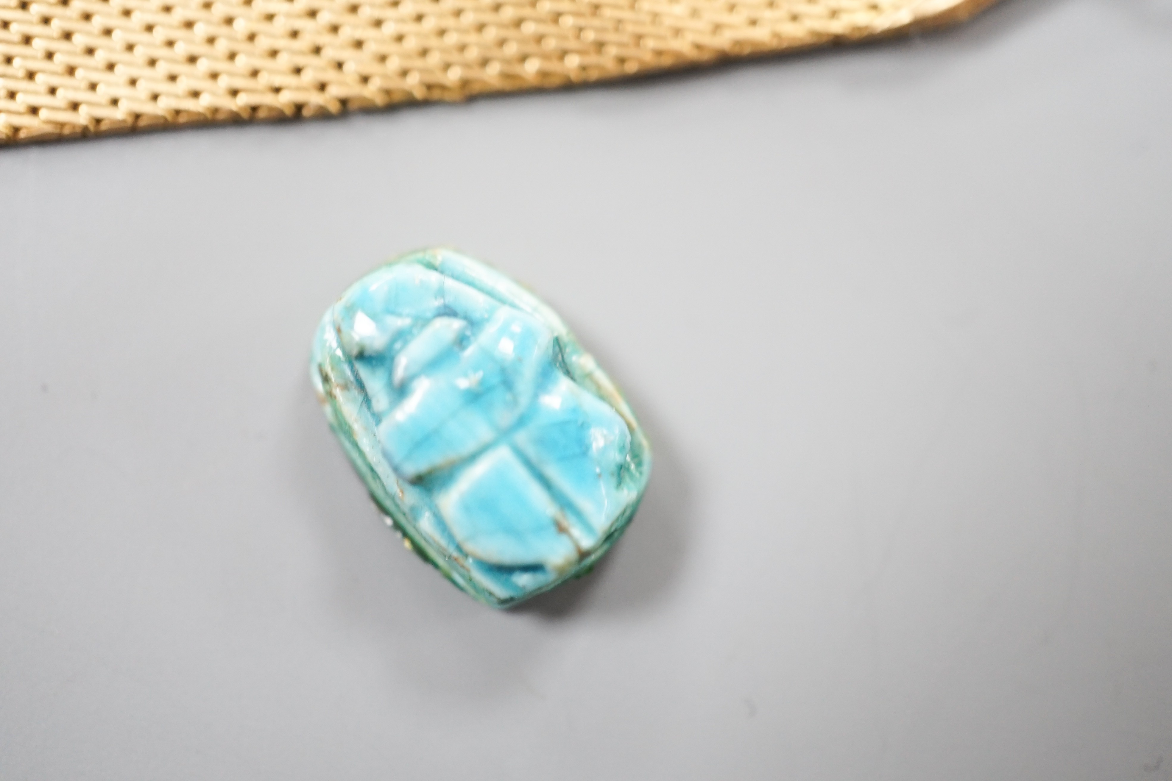 A Middle Eastern yellow metal and enamel pendant on a similar clip and three other Middle eastern pendants, one with chain, gross weight 34.5 grams and an Egyptian scarab.